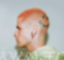  Profile image of a man with pink hair and a smiley face dyed on the back of his head, with white text at the bottom. 